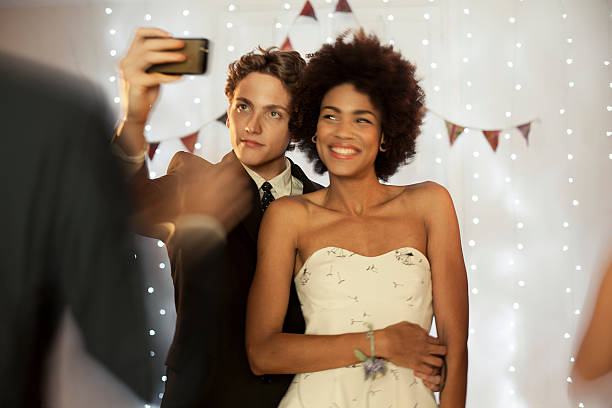 a girl and guy taking a selfie at prom